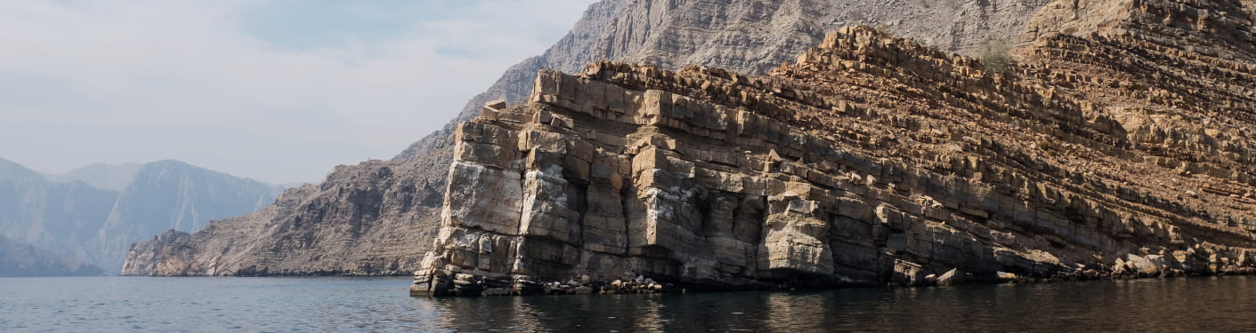 Felsige Küste an der Straße von Hormuz in Nordoman mit steil aus dem Meer aufragenden Klippen.